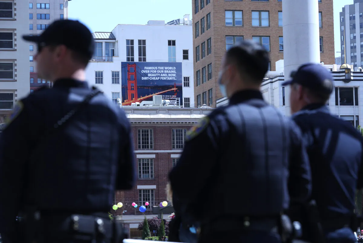 San Francisco police officers look on near a billboard that warns against fentanyl in San Francisco on April 4, 2022. (Justin Sullivan/Getty Images)
