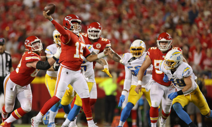 Patrick Mahomes (15) of the Kansas City Chiefs scrambles and throws the ball for a touchdown during the third quarter against the Los Angeles Chargers at Arrowhead Stadium in Kansas City, on Sept. 15, 2022. (Jamie Squire/Getty Images)