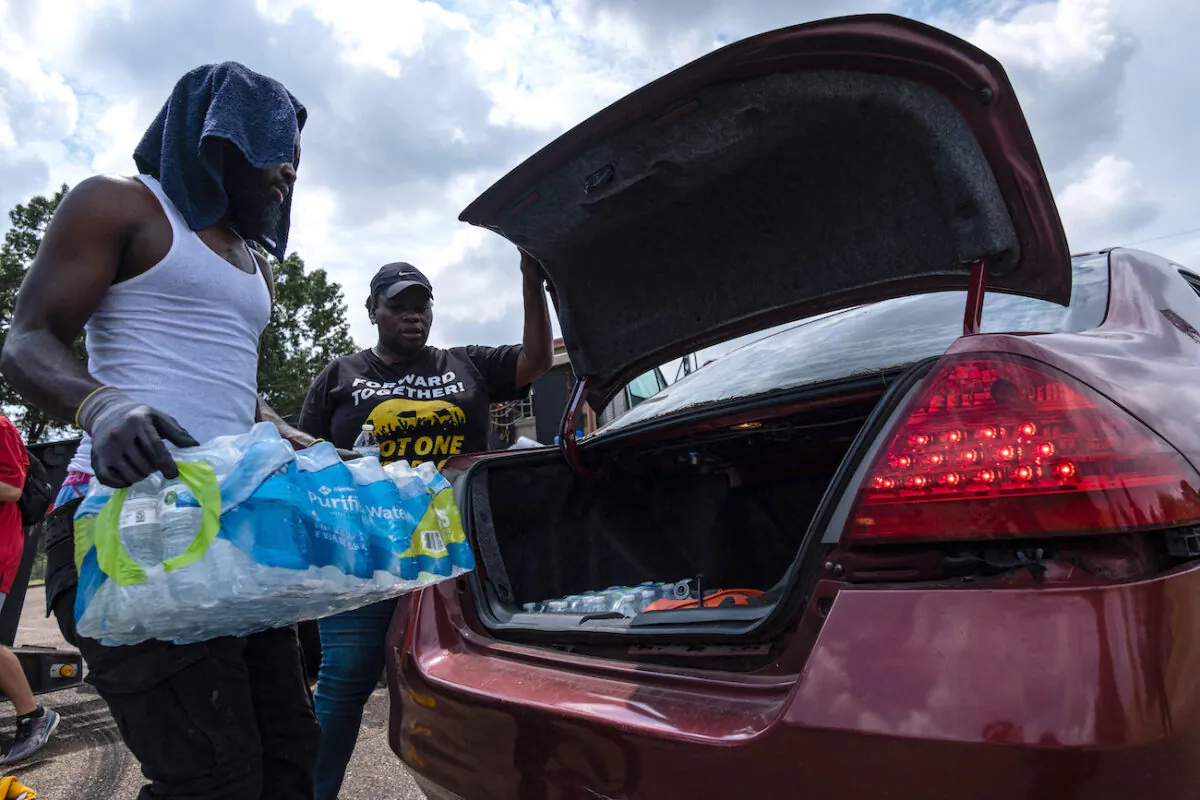 Residents distribute cases of water at Grove Park Community Center in Jackson, Miss., on Sept. 3, 2022. (Seth Herald/AFP via Getty Images)