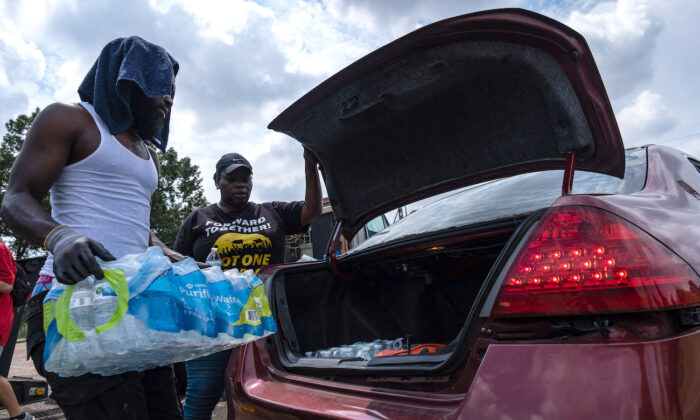Residents distribute cases of water at Grove Park Community Center in Jackson, Miss., on Sept. 3, 2022. (Seth Herald/AFP via Getty Images)