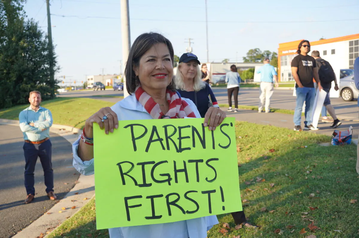 Fairfax County resident Lin-Dai Kendall protests at a rally outside Luther Jackson Middle School before a Fairfax County Public Schools board meeting in Falls Church, Va., on Sept. 15, 2022. (Terri Wu/The Epoch Times)