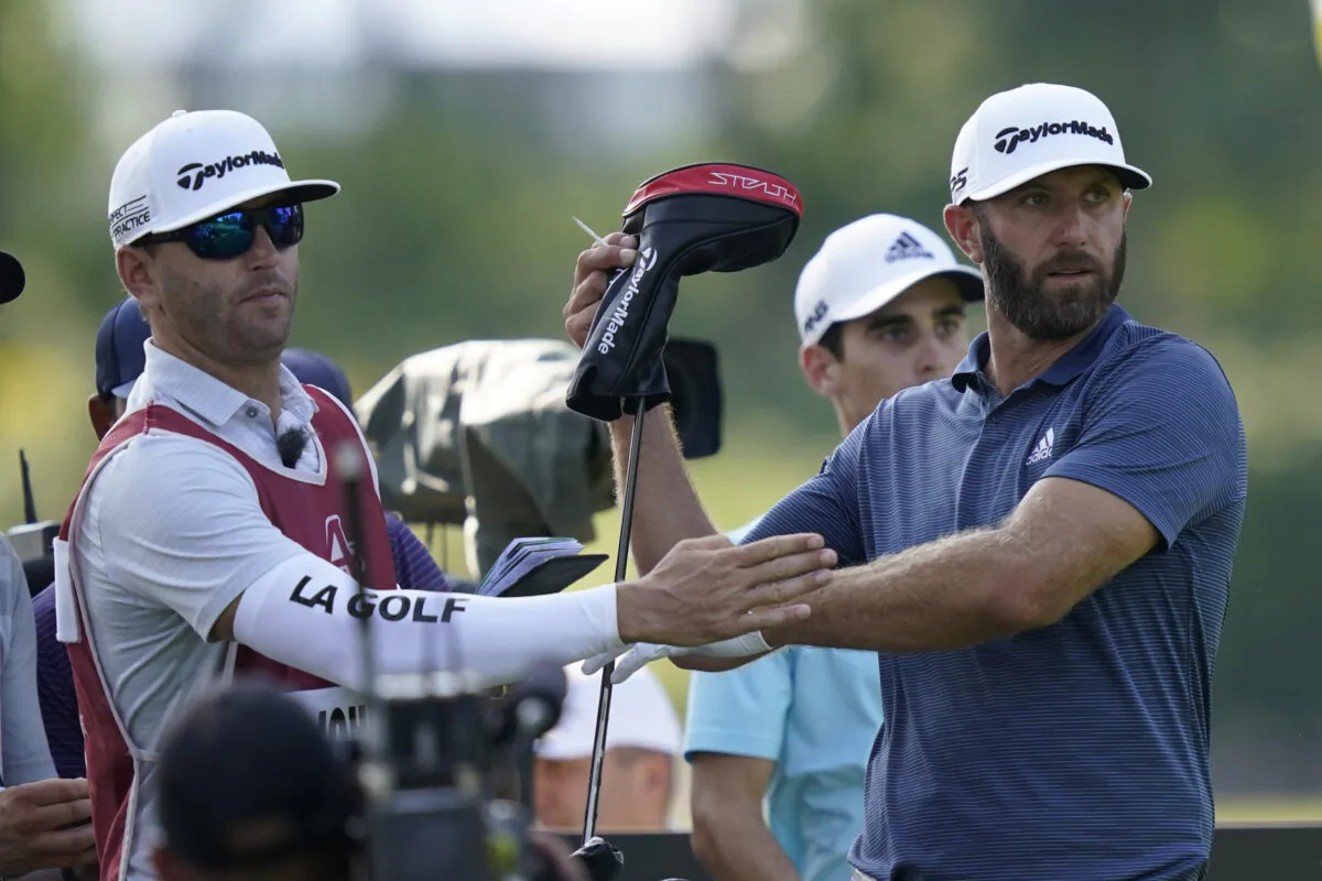Dustin Johnson pulls a driver from his bag during the first round of the LIV Golf Invitational-Chicago tournament in Sugar Grove, Ill., on Sept. 16, 2022. (Charles Rex Arbogast/AP Photo)