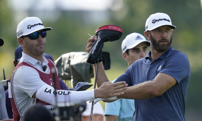 Dustin Johnson pulls a driver from his bag during the first round of the LIV Golf Invitational-Chicago tournament in Sugar Grove, Ill., on Sept. 16, 2022. (Charles Rex Arbogast/AP Photo)