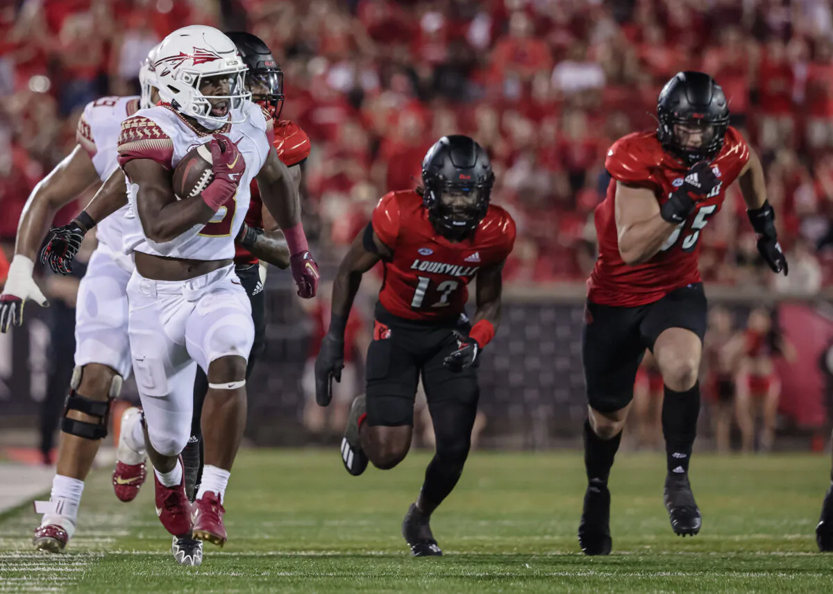 Trey Benson (3) of the Florida State Seminoles runs the ball as Devaughn Mortimer (12) and Mason Reiger (95) of the Louisville Cardinals pursue during the second half at Cardinal Stadium in Louisville, Ky., on Sept. 16, 2022. (Michael Hickey/Getty Images)