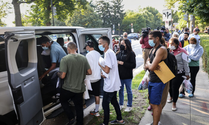 Illegal immigrants from Central and South America load into vans near the residence of Vice President Kamala Harris after being dropped off in Washington, on Sept. 15, 2022. (Kevin Dietsch/Getty Images)
