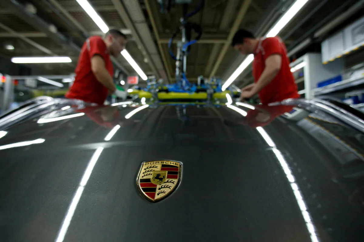 Employees of German car manufacturer Porsche install the windshield of a Porsche 911 at the Porsche factory in Stuttgart-Zuffenhausen, Germany, on Feb. 19, 2019. (Ralph Orlowski/Reuters)