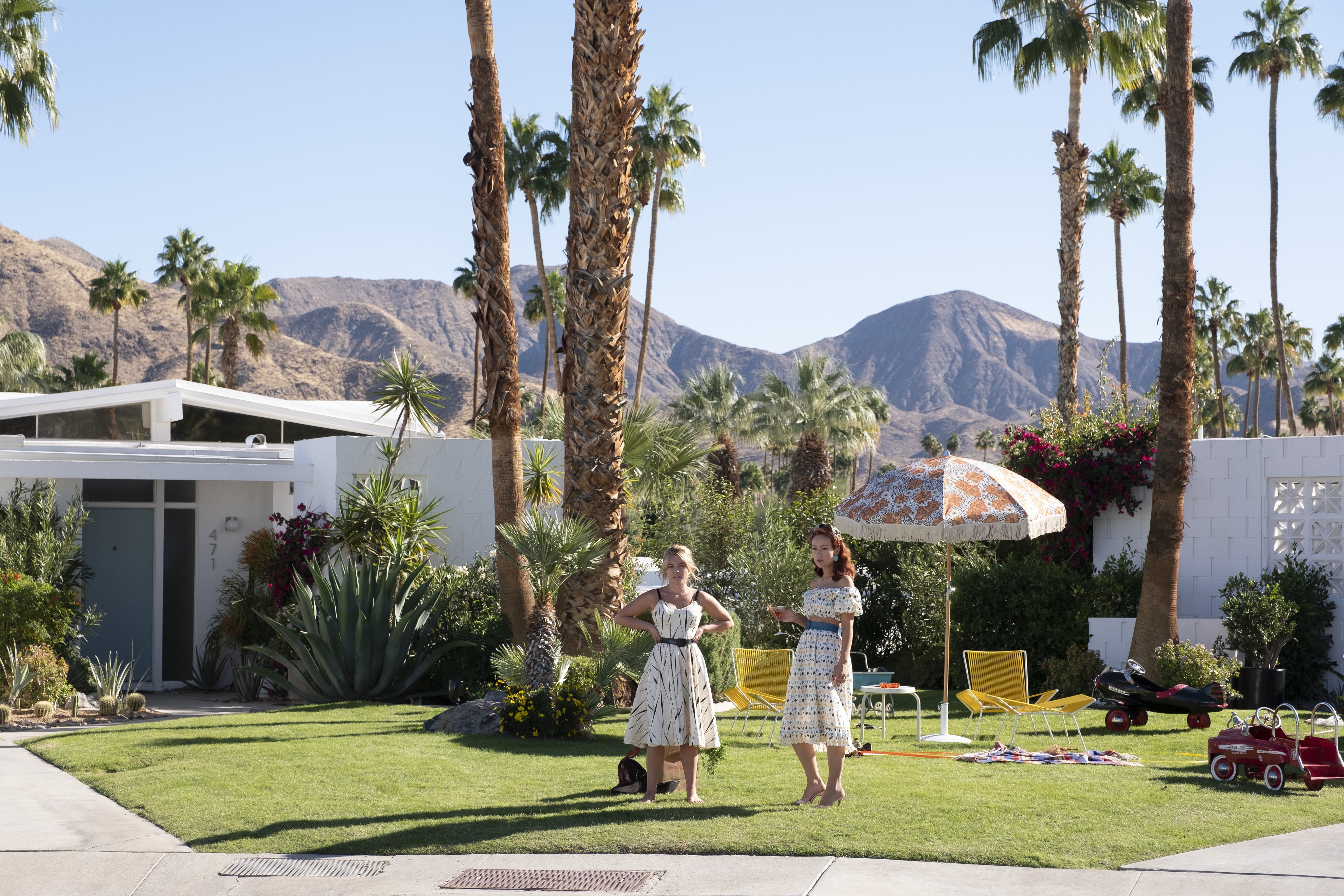 two women talk on a lawn in DON'T WORRY DARLING