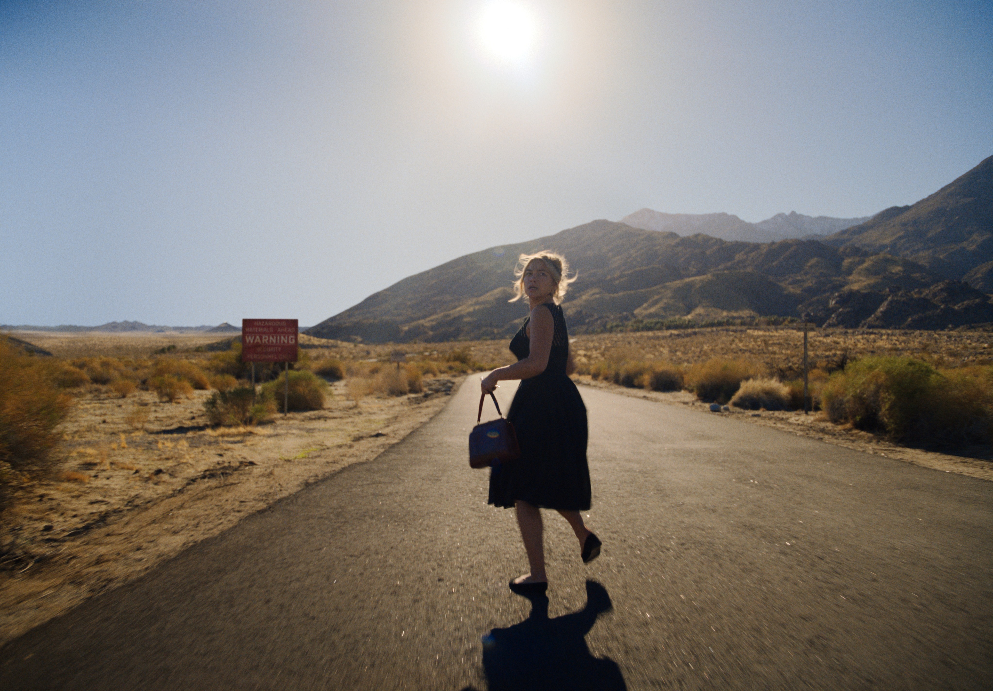 woman running on a road in DON'T WORRY DARLING