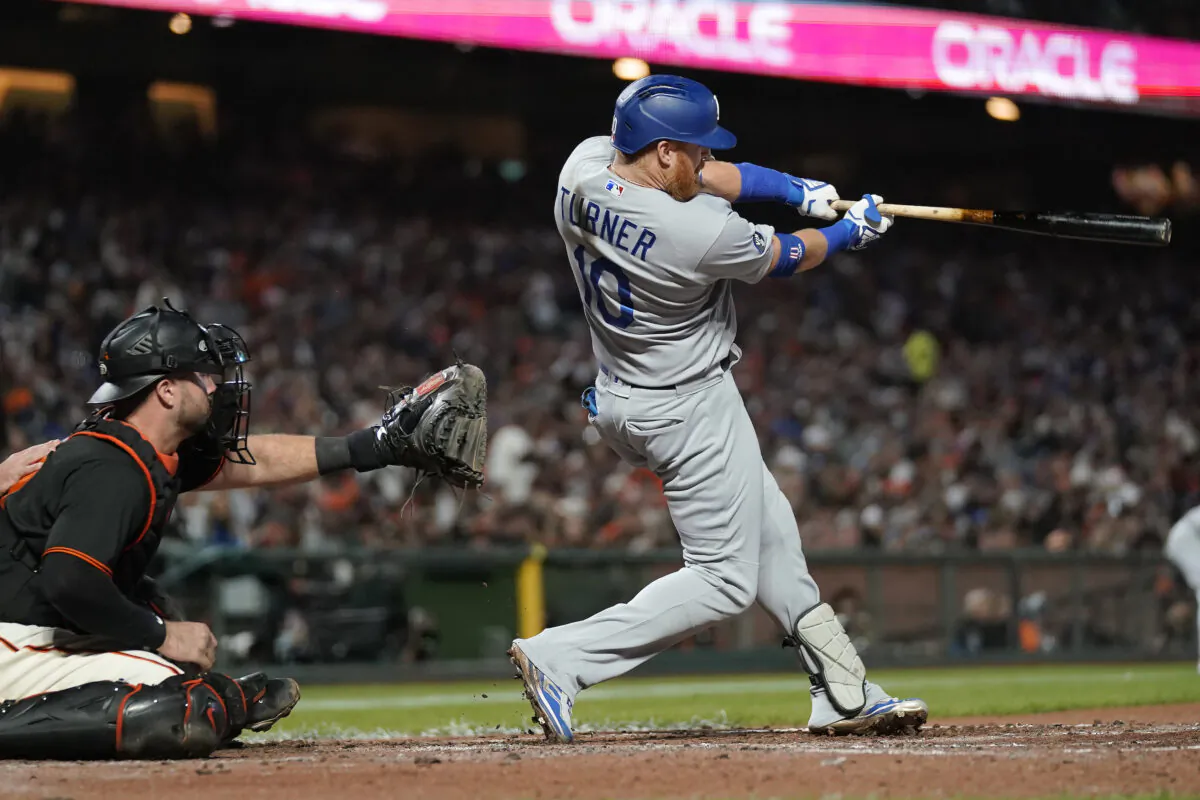 Los Angeles Dodgers designated hitter Justin Turner, right, hits an RBI single in front of San Francisco Giants catcher Joey Bart during the fourth inning of a baseball game in San Francisco, on Sept. 17, 2022. (Jeff Chiu/AP Photo)