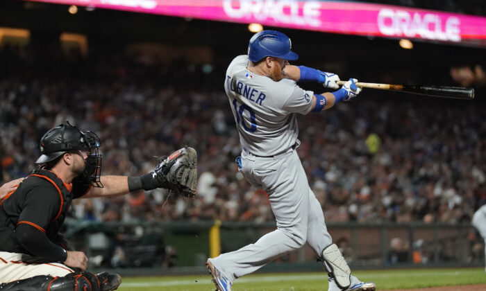 Los Angeles Dodgers designated hitter Justin Turner, right, hits an RBI single in front of San Francisco Giants catcher Joey Bart during the fourth inning of a baseball game in San Francisco, on Sept. 17, 2022. (Jeff Chiu/AP Photo)