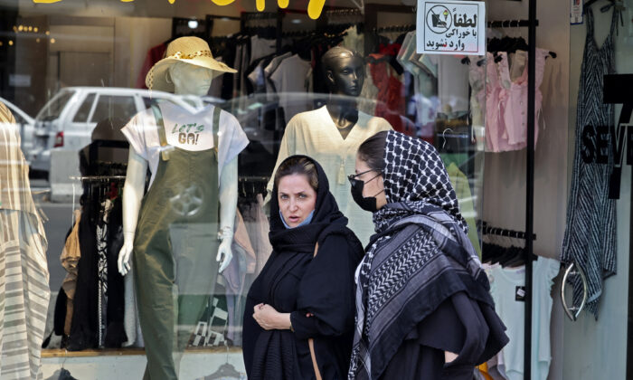 Women wearing headscarves walk in the streets of Tehran near, Tajrish Square, on July 12, 2022. Since the country's 1979 Islamic revolution, Iranian law requires all women, regardless of nationality or religious belief, to wear a hijab that covers the head and neck while concealing the hair. But many have pushed the boundaries over the past two decades by allowing their head coverings to slide back and reveal more hair, especially in Tehran and other major cities. (ATTA KENARE/AFP via Getty Images)