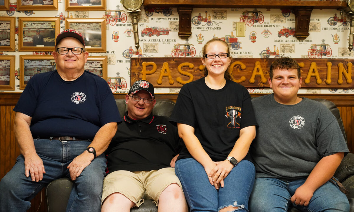 David Moore Sr. (L), David Moore Jr. (2nd L), Briana Moore (2nd R), and David Moore (R) at the meeting room of Neversink Engine Company in Port Jervis, N.Y., on Sept. 9, 2022. (Cara Ding/The Epoch Times)