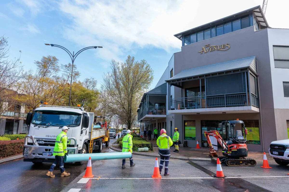 Work crew repair a burst water main pipe that created a sink hole in Centro Avenue in the suburb of Subiaco in Perth, Australia on Sep. 19, 2022. West Australian authorities have apologised over a burst water pipe which left a luxury car submerged in a sinkhole in the Perth suburb of Subiaco. (AAP Image/Richard Wainwright)