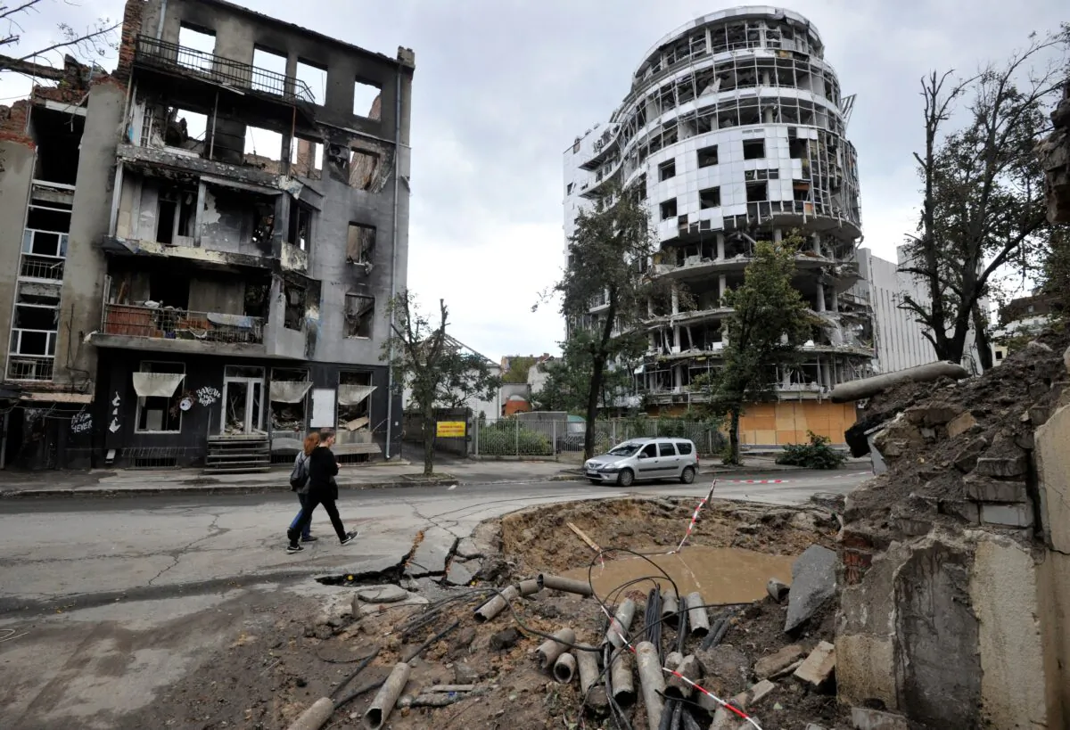 People walk by a destroyed building following shelling in the center of Kharkiv, Ukraine, on Sept. 18, 2022. (Sergei Chuzavkov/AFP via Getty Images)