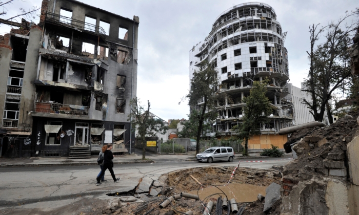People walk by a destroyed building following shelling in the center of Kharkiv, Ukraine, on Sept. 18, 2022. (Sergei Chuzavkov/AFP via Getty Images)