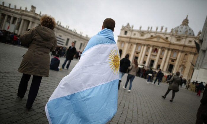 A boy walks in St. Peter's Square wrapped in the flag of Argentina before Pope Francis gave his first Angelus blessing in Vatican City, Vatican, on March 17, 2013. (Peter Macdiarmid/Getty Images)