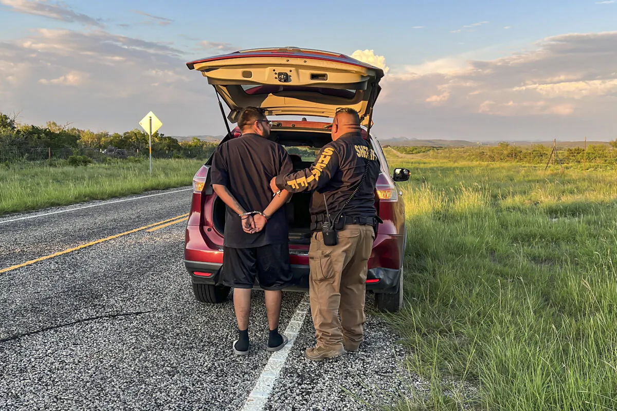 A Kinney County sheriff’s deputy arrests an illegal alien being smuggled from the U.S.–Mexico border, through Kinney County, Texas, on Sept. 10, 2022. (Charlotte Cuthbertson/The Epoch Times)