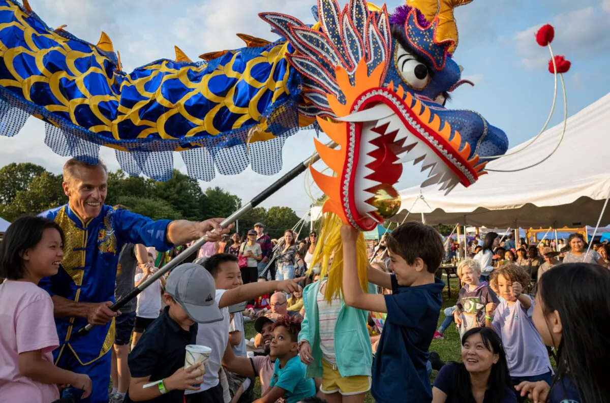 A dragon dance performer interacts with kids at the Moon Festival in Deerpark, New York, on Sept. 17, 2022. (Courtesy of Mark Zou/New Century Film)
