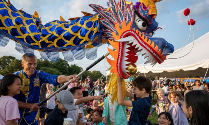 A dragon dance performer interacts with kids at the Moon Festival in Deerpark, New York, on Sept. 17, 2022. (Courtesy of Mark Zou/New Century Film)