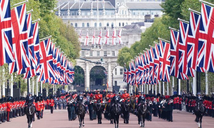 The State Gun Carriage carries the coffin of Queen Elizabeth II, draped in the Royal Standard with the Imperial State Crown and the Sovereign's orb and sceptre, in the Ceremonial Procession following her state funeral at Westminster Abbey, London, on Sept. 19, 2022. (Ian West/PA Media)