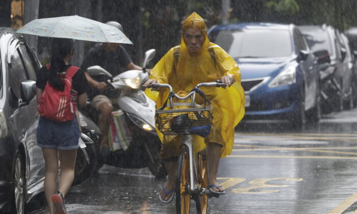 2022 年 9 月 3 日，台湾台北，台风“欣南诺”即将来临，人们在雨中前行。（蒋英英/美联社照片）