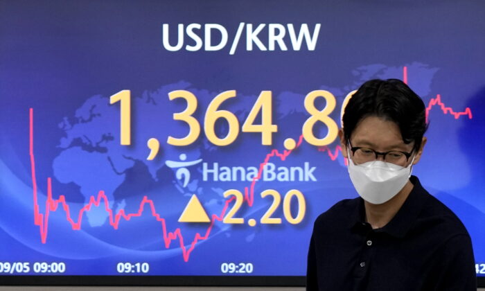 2022 年 9 月 5 日，在韩国首尔的一家外汇交易室，一名外汇交易员走过显示美元和韩元之间外汇汇率的屏幕。（Lee Jin-man/AP Photo）