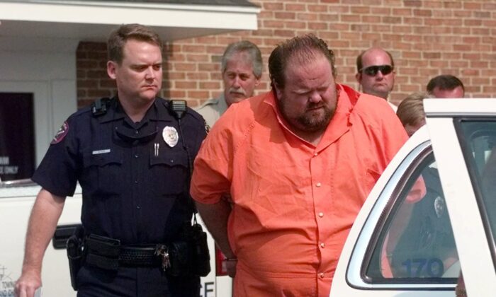 Officials escort murder suspect Alan Eugene Miller away from the Pelham City Jail in Ala., on Aug. 5, 1999. (Dave Martin/AP Photo)