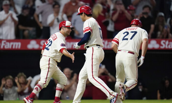 Los Angeles Angels designated hitter Shohei Ohtani (17) celebrates with David Fletcher (22) and Mike Trout (27) after hitting a home run during the sixth inning of a baseball game against the New York Yankees in Anaheim, Aug. 31, 2022. (Ashley Landis/ AP Photo)