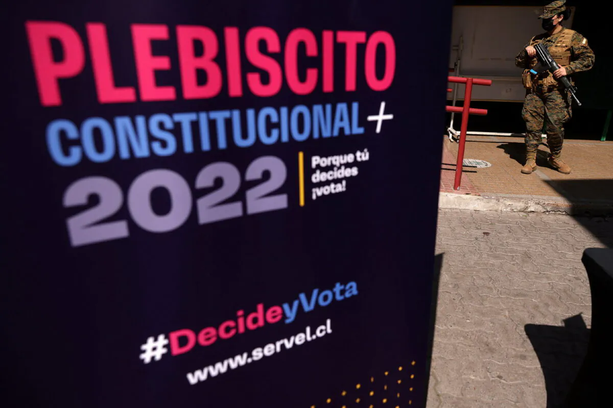 A soldier stands guard inside a school used as a trial vote polling station ahead of the Sept. 4 constitutional referendum in Santiago, Chile, on Sept. 2, 2022. The sign reads 'Constitutional Referendum 2022.' (Ivan Alvarado/Reuters)