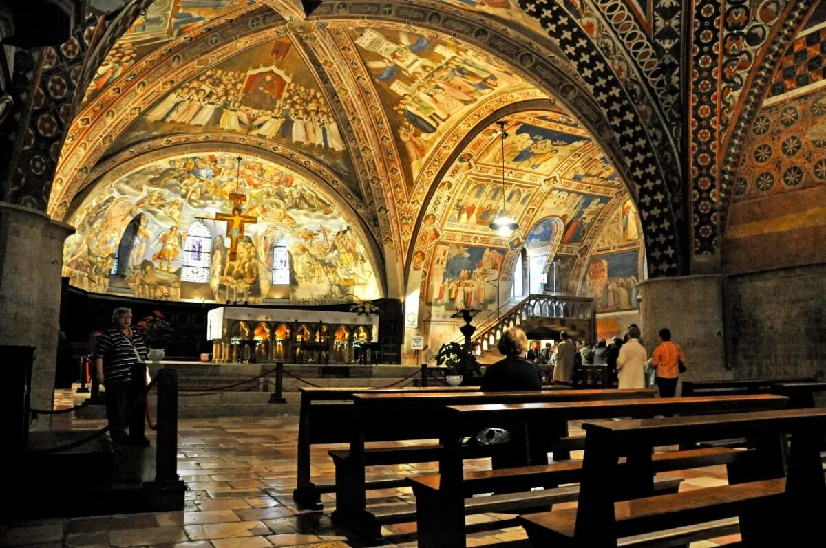 The interior of the Basilica of St. Francis of Assisi in the Umbria region of Italy shows the papal altar of the lower church, with Gothic walnut choir stalls. On the walls are “Last Judgment” frescos by Cesare Sermei di Orvieto (1609–1668), and the vaults have paintings by Maestro delle Vele, depicting the “Triumph of Saint Francis.” The stained-glass windows are attributed to Giovanni di Bonino. (Dennis Jarvis/CC BY-SA 2.0)