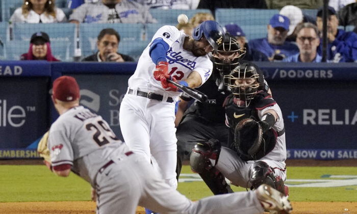 Los Angeles Dodgers' Joey Gallo, second from left, hits a solo home run as Arizona Diamondbacks starting pitcher Merrill Kelly, left, watches along with catcher Carson Kelly, right, and home plate umpire Adam Beck during the second inning of a baseball game in Los Angeles, on Sept. 19, 2022. (Mark J. Terrill/AP Photo)