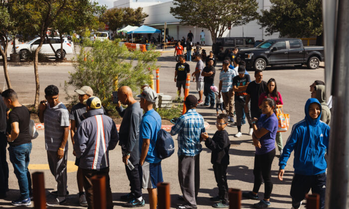 Groups of asylum seeking illegal immigrants wait outside the Migrant Resource Center to receive food from the San Antonio Catholic Charities in San Antonio, Texas, on Sept. 19, 2022. (Jordan Vonderhaar/Getty Images)