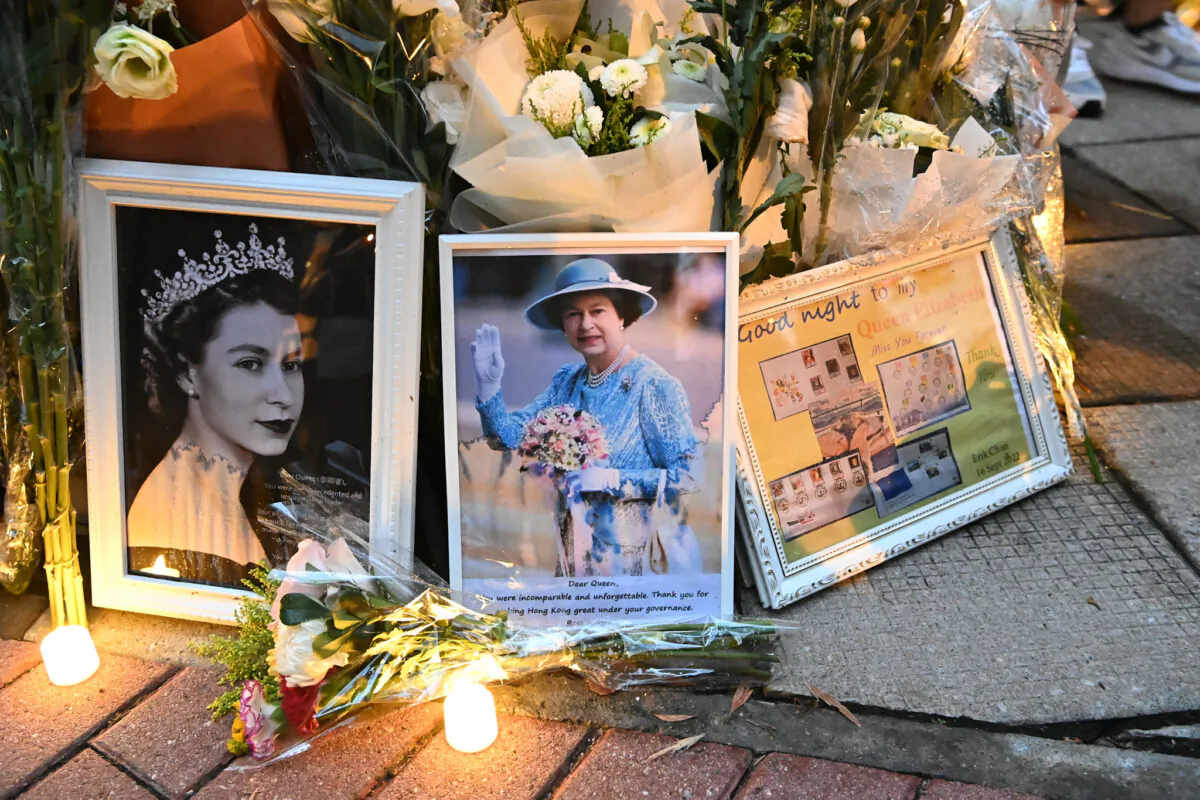 Members of the public mourned the passing of Queen Elizabeth II with flowers and candles outside the British Consulate General in Hong Kong on Sept. 19, 2022. (Sung Pi-lung/The Epoch Times)
