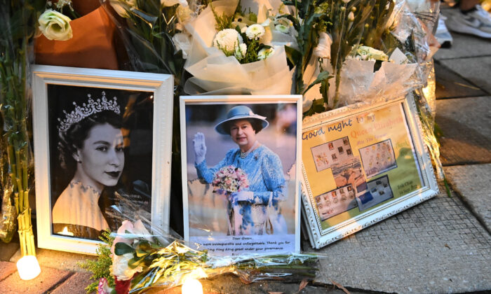 2022年9月19日，英国驻香港总领事馆外，民众举着鲜花和蜡烛悼念伊丽莎白二世女王。（宋丕龙/）
