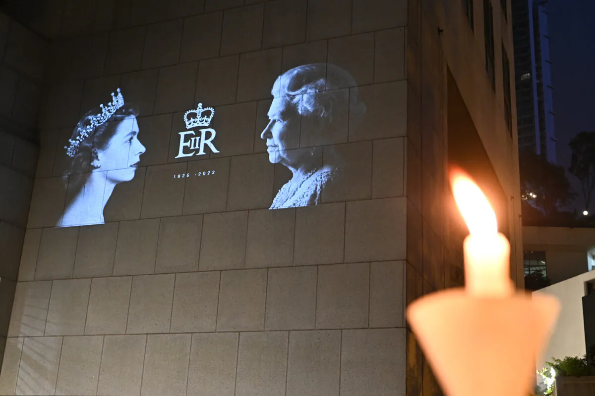 Members of the public mourn the passing of Queen Elizabeth II with flowers and candles outside the British Consulate General in Hong Kong on Sept. 19, 2022. (Sung Pi-lung/The Epoch Times)