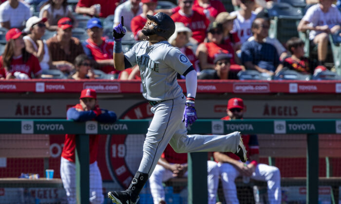Seattle Mariners' Carlos Santana points skyward while rounding the bases after hitting a grand slam against the Los Angeles Angels during the fifth inning of a baseball game in Anaheim, Calif., on Sept. 19, 2022. (Alex Gallardo/AP Photo)