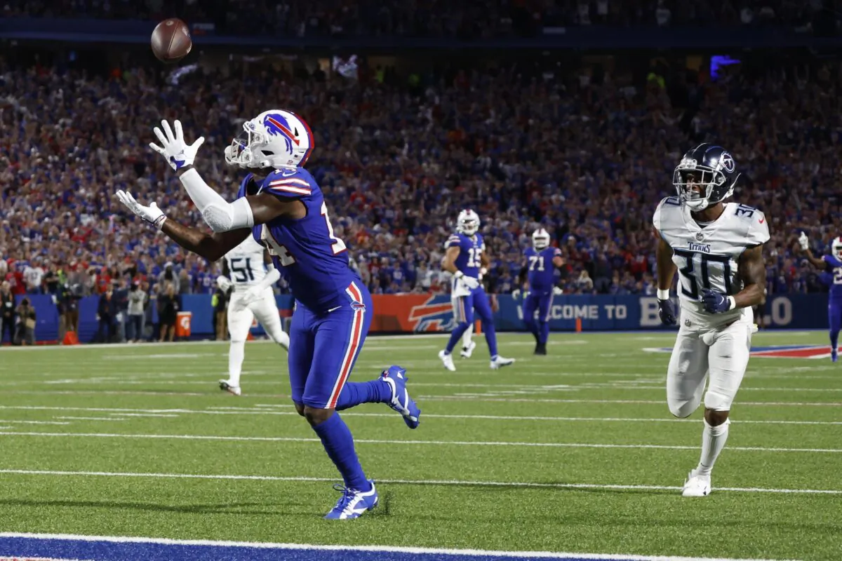 Buffalo Bills' Stefon Diggs, left, catches a pass for a touchdown in front of Tennessee Titans' Tre Avery (30) during the second half of an NFL football game Monday, Sept. 19, 2022, in Orchard Park, N.Y. (AP Photo/Jeffrey T. Barnes)