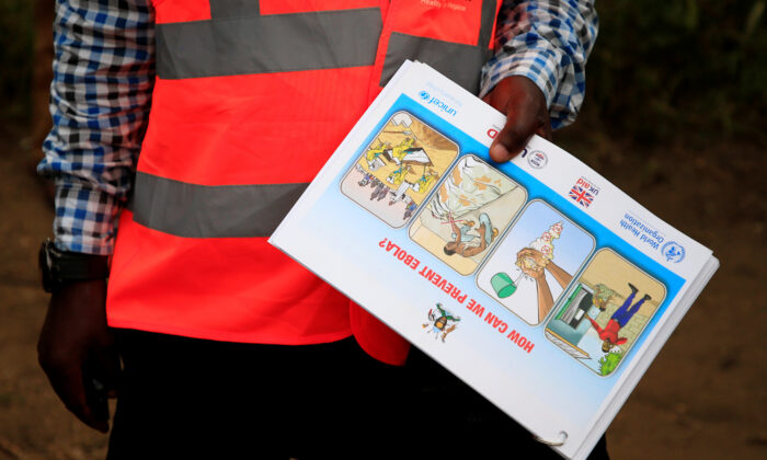 An Ugandan health worker shows an informational flyer on Ebola virus and how to prevent its spread to the community of Kirembo village, near the border with the Democratic Republic of Congo, in Kasese district, Uganda, on June 15, 2019. (James Akena/Reuters)