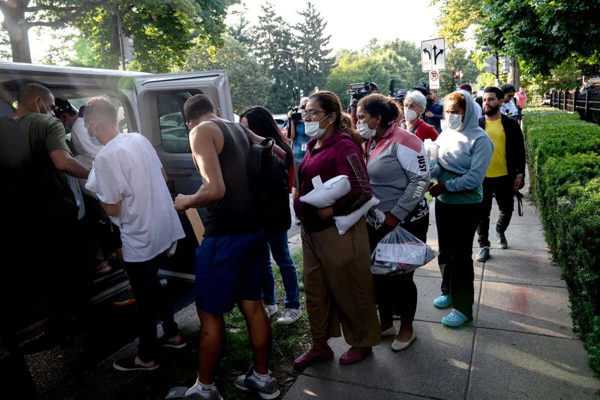 Illegal immigrants from Venezuela, who boarded a bus in Texas, wait to be transported to a local church by volunteers after being dropped off outside the residence of Vice President Kamala Harris, at the Naval Observatory in Washington, on Sept. 15, 2022. (Stefani Reynolds/AFP via Getty Images)