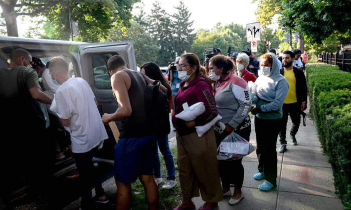 Illegal immigrants from Venezuela, who boarded a bus in Texas, wait to be transported to a local church by volunteers after being dropped off outside the residence of Vice President Kamala Harris, at the Naval Observatory in Washington, on Sept. 15, 2022. (Stefani Reynolds/AFP via Getty Images)