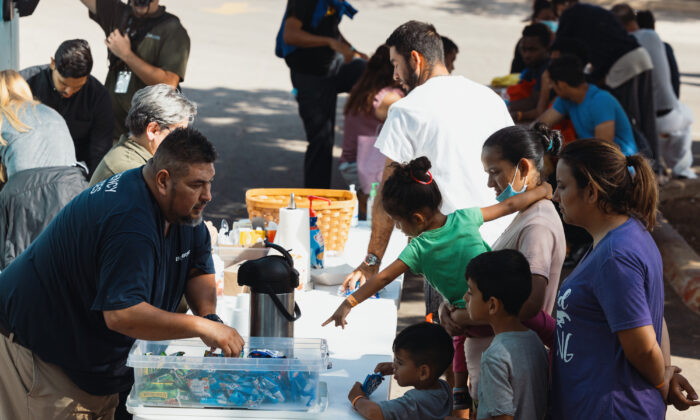 Groups of illegal immigrants receive food from the San Antonio Catholic Charities outside the Migrant Resource Center in San Antonio, Texas, on Sept. 19, 2022. The City of San Antonio Migrant Resource Center is the origin place of the two planeloads of mostly Venezuelan migrants who were sent via Florida to Martha’s Vineyard by Florida Gov. Ron DeSantis. (Jordan Vonderhaar/Getty Images)