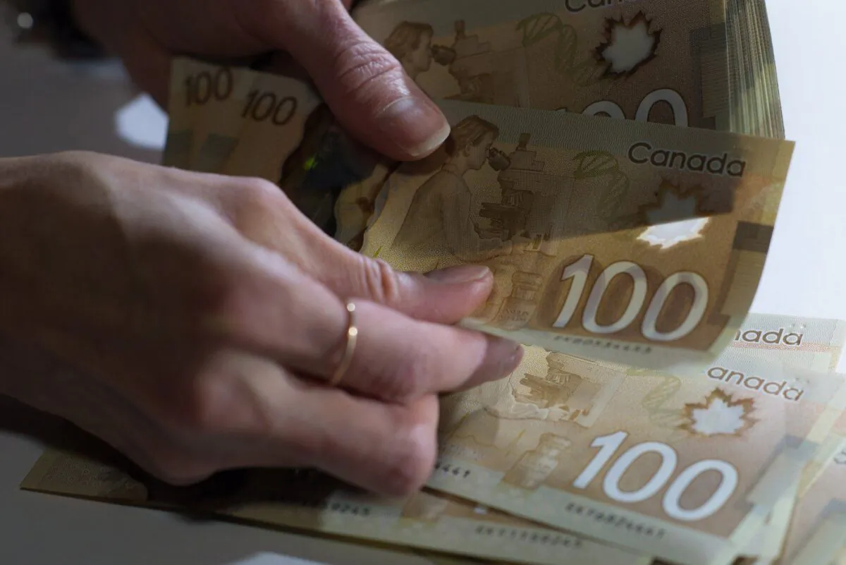 Canadian $100 bills are counted in Toronto on Feb. 2, 2016. (Graeme Roy/The Canadian Press)