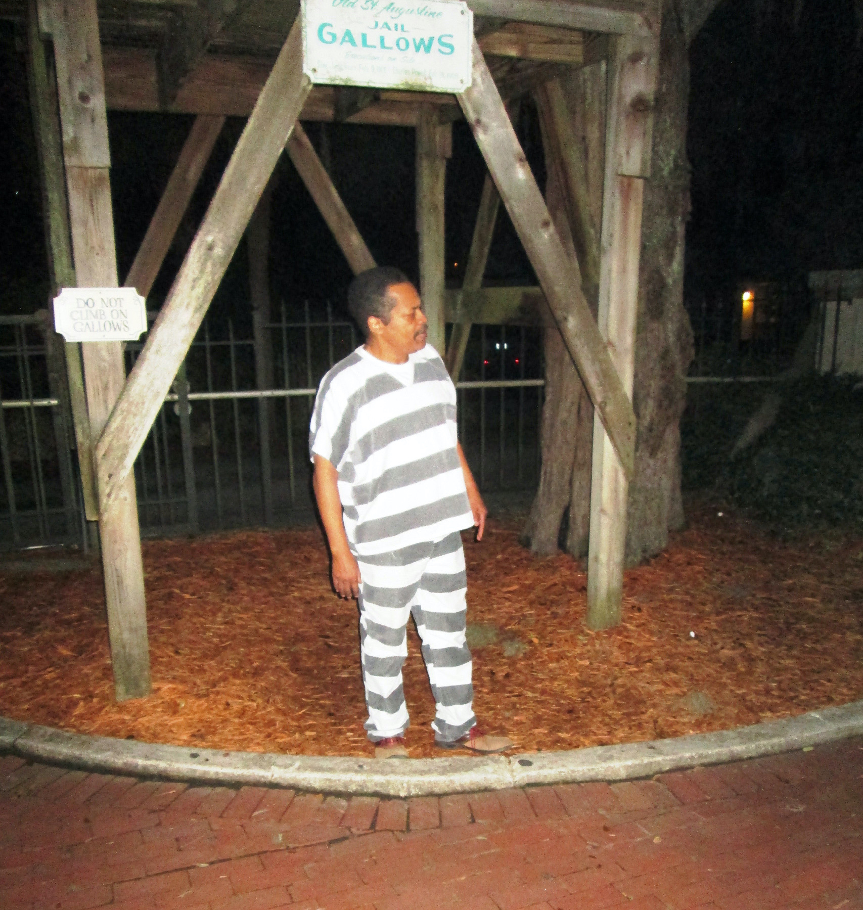 A costumed interpreter at the Hanging Jail in St. Augustine, Florida, tells members of a ghost tour about events that took place there in the past.
