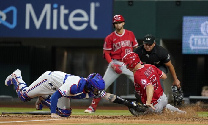 Texas Rangers catcher Jonah Heim tags out Los Angeles Angels' Matt Duffy (5) as umpire Roberto Ortiz and Angels' Livan Soto, rear, watch during the fourth inning of a baseball game in Arlington, Texas, on Sept. 20, 2022. (Tony Gutierrez/AP Photo)