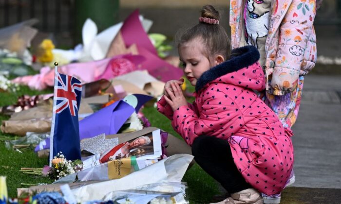 Children lay flowers outside Government House following the passing of Britain's Queen Elizabeth II in Melbourne, Australia, on Sept. 10, 2022. (William West/AFP via Getty Images)