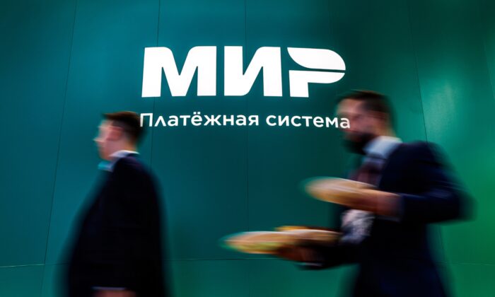 People walk past the logo of Russian payment system Mir at the St. Petersburg International Economic Forum (SPIEF) in Saint Petersburg, Russia, on June 15, 2022. (Maxim Shemetov/Reuters)
