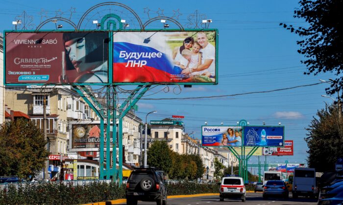 Vehicles drive past advertising boards, including panels displaying pro-Russian slogans, on a street in Luhansk, Ukraine, on Sept. 20, 2022. (Alexander Ermochenko/Reuters)