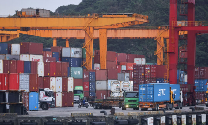 2022 年 1 月 7 日，货运卡车在台湾基隆的一个集装箱堆场内工作。（Ann Wang/路透社）