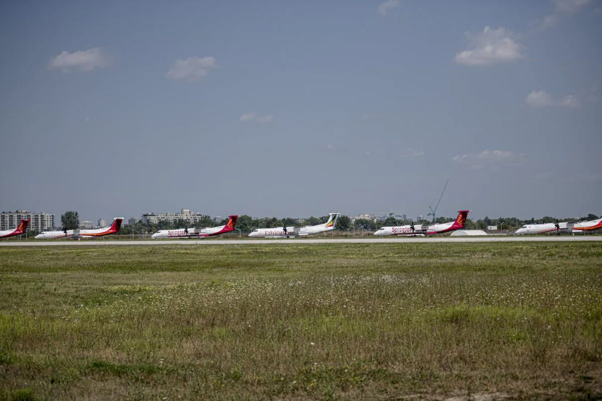 A row of De Havilland Dash-8 airplanes sit outside the Downsview plant in Toronto on Aug. 24, 2021. (The Canadian Press/Christopher Katsarov)