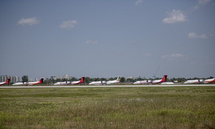 A row of De Havilland Dash-8 airplanes sit outside the Downsview plant in Toronto on Aug. 24, 2021. (The Canadian Press/Christopher Katsarov)